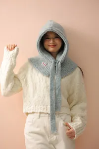 Close-up of light blue knitted balaclava hood with fuzzy texture and woven brand label