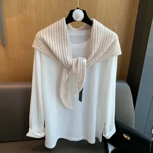 Détail du châle en laine tricotée beige avec une texture élégante en maille côtelée