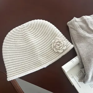 Detail view of cream crochet beanie with 3D flower ornament and ribbed knit texture