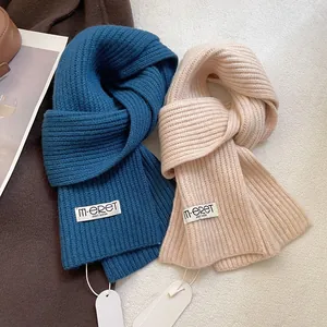 Close-up of premium thick ribbed knit wool scarves in navy and beige with brand labels