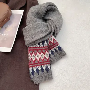 Dettaglio del motivo Fair Isle su una sciarpa grigia in maglia spessa e rossa
