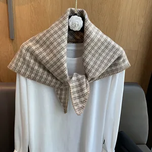 Detail of vintage brown and beige plaid woven scarf with high-quality overlock stitching edge