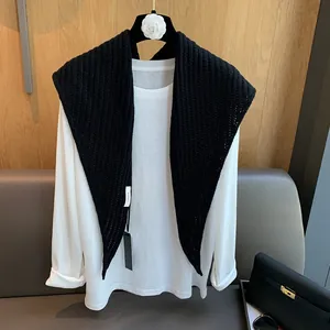 Détail de l'étiquette 100% laine sur un châle en maille épaisse de couleur noire