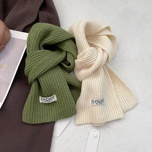 Detail of premium wool knit scarves in olive green and cream white with rib texture