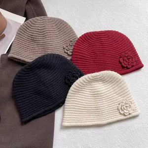Chic knit flower beanies in black, cream, red, and khaki with wavy crochet texture