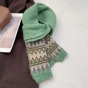 Dettaglio del motivo jacquard geometrico su una sciarpa in maglia spessa verde erba