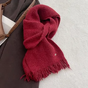 Detail of red wool blend knit scarf with shimmering silver threads and fringe edges