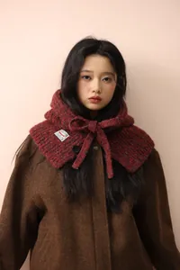Detail of red wool blend knit balaclava with adjustable bow tie on a wool coat