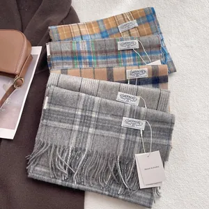 Classic British plaid 100% wool scarf with fringe detail on a stylish brown winter coat