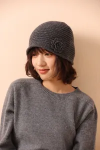 Close-up of knit beanie with handmade 3D floral accent and fine wool texture