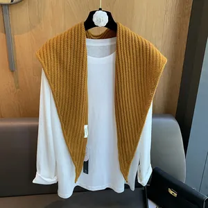 Détail de l'étiquette 100% pure laine sur un châle en tricot moutarde pour l'automne