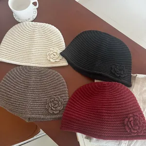 Detailed knit texture and crochet flower accents on assorted vintage winter beanies
