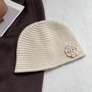 Detail of crochet camellia flower on cream white chunky knit beanie for women