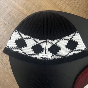 Detailed view of 100% wool label on thick black and white diamond knit beanie