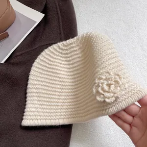 Detailed close-up of cream white ribbed knit bucket hat with 3D floral accent detail