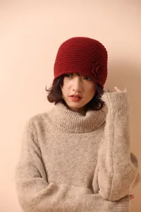 Detailed close-up of dark red crochet flower on a fine knit beanie for women