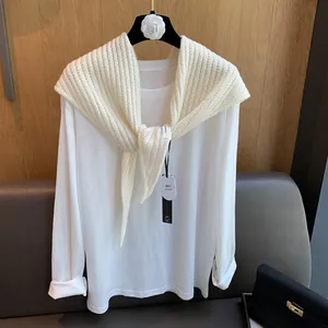 Détail du châle en laine avec étiquette 100% laine et texture de tricot doux