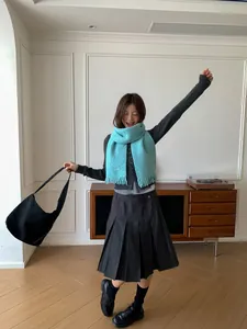 Sky blue wool blend fringed scarf paired with a grey knit cardigan and black pleated skirt