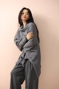 Detail of soft grey knit oversized poncho cape showing high-quality texture and drape