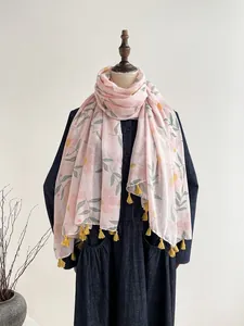 Detailed texture of cotton linen scarf featuring floral prints and yellow tassels