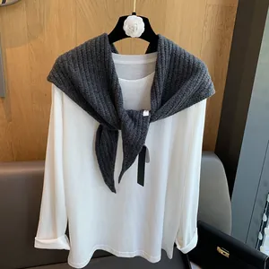 Détail de la texture d'un châle en laine 100% gris côtelé sur un t-shirt blanc