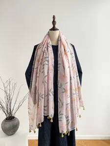Detail of pink cotton linen scarf with yellow floral prints and delicate fringe tassels