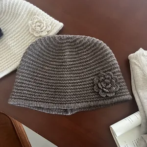 Detail of handmade crochet knit beanie featuring a 3D flower and ribbed texture