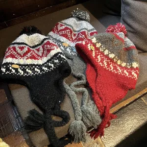 Bonnets tricotés avec protège-oreilles style ethnique et pompons en trois motifs