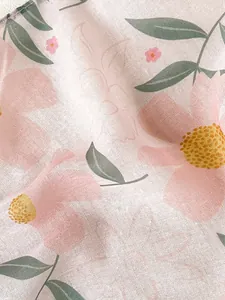 Macro detail of breathable floral cotton linen fabric showing delicate weave and soft pattern
