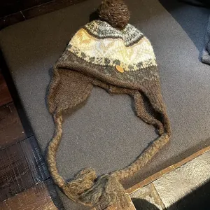 Détail du bonnet d'hiver en tricot avec cache-oreilles, motif jacquard et étiquette cuir