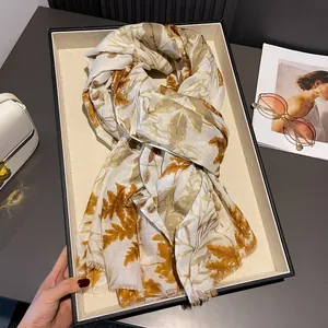 Ivory linen scarf with golden maple leaf patterns and elegant fringe edges for sun protection
