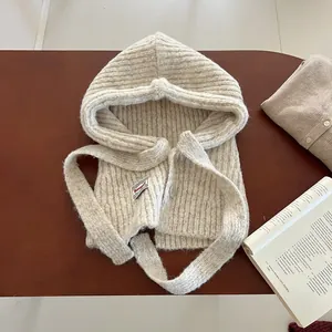 Detail of oat-colored knitted balaclava showing ribbed texture and button closure