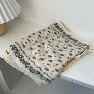 Floral pleated long scarf in cream with purple flowers and green leaves on white surface