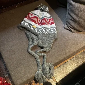 Texture de tricot détaillée avec motif géométrique et pompon sur le bonnet à oreillettes