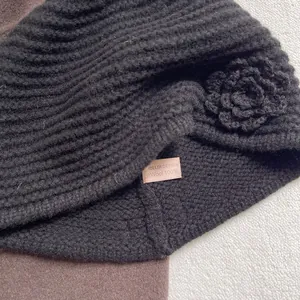 Detail view of 100% wool knitted hat showing premium texture and 3D crochet flower