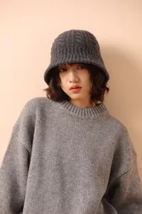 Close-up of gray merino wool knit bucket hat with premium cable texture and warm feel
