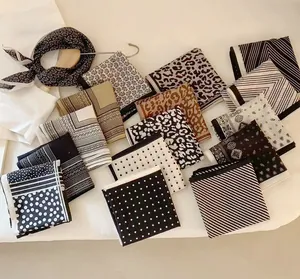 Detailed flat lay of silk scarves showing polka dot, stripe, and leopard patterns
