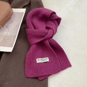 Close-up of deep magenta ribbed knit wool scarf texture with elegant brand label