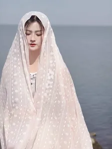 Close-up of lightweight pink cotton linen shawl with white geometric floral embroidery