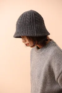 Close-up of chunky cable knit texture on dark grey pure merino wool bucket hat