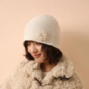 Women's knit beanie in cream white featuring crochet flower detail for autumn and winter