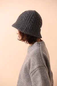 Detail of dark grey merino wool knitted bucket hat with classic cable knit texture