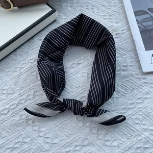 Close-up of black and white striped silk cotton neckerchief with elegant knotted styling