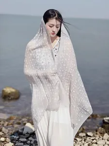 Detail of white cotton linen shawl featuring a geometric cross pattern and textured edges