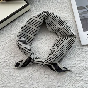 Detail of elegant black and white striped silk scarf with premium hemmed edges