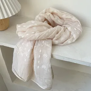 Detail of light pink cotton linen scarf with white polka dots and geometric embroidery
