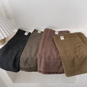 Écharpes en lin rayé style japonais en quatre couleurs pliées sur une table minimaliste