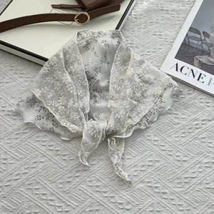 Detail of floral cotton linen triangle scarf with delicate lace edging and petal patterns