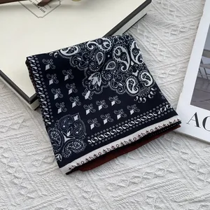 Primer plano de pañuelo bandana paisley plegado con detalles en blanco y negro de algodón