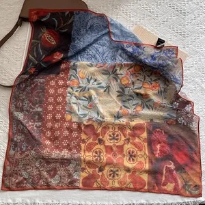 Detail of vintage floral silk-feel scarf with artistic pomegranate and bird patterns